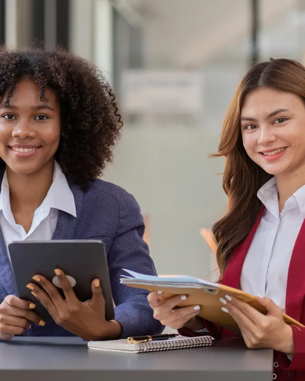 Two financial advisers with a tablet and laptop